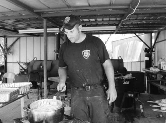 Hoover Valley Volunteer Fire Department Capt. Marc Talamantez fires up french fries during the department fish fry fund raiser June 4 in Burnet.